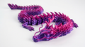 3D-printed dragon model in purple and pink on a white background