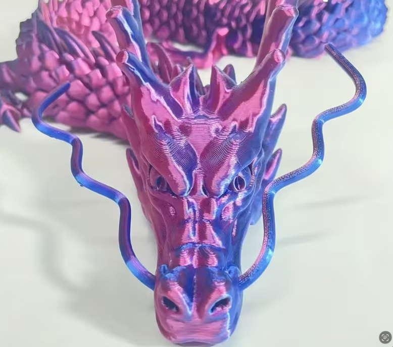 Colorful 3D-printed dragon head model on a white background